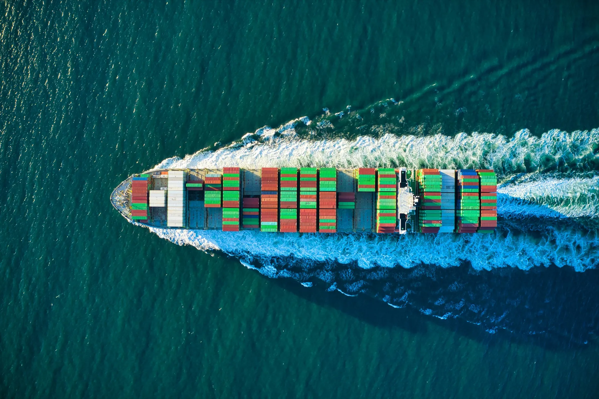 Container vessel carrying cargo across open water